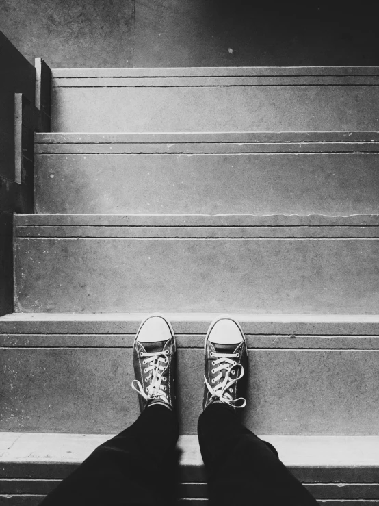 person standing on stairs and wearing sneakers