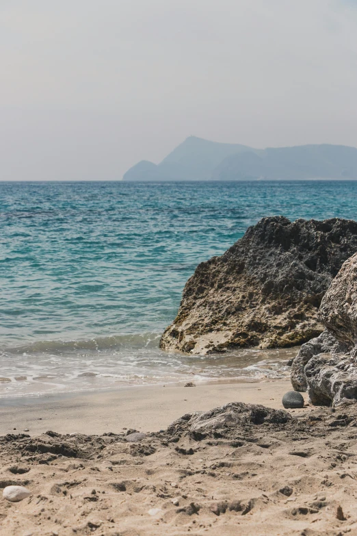 a beach with many waves and rocks on the shore