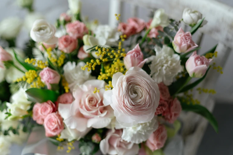 bouquet of roses and other flowers sitting on a chair