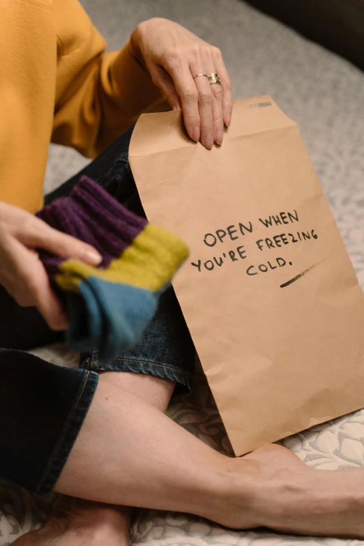 a person is holding up a paper bag with writing on it