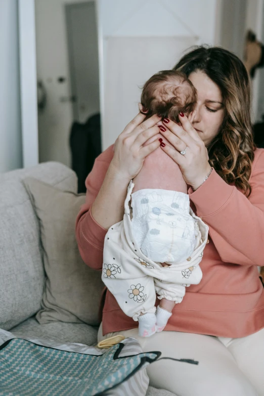 a woman holds her baby in the arms