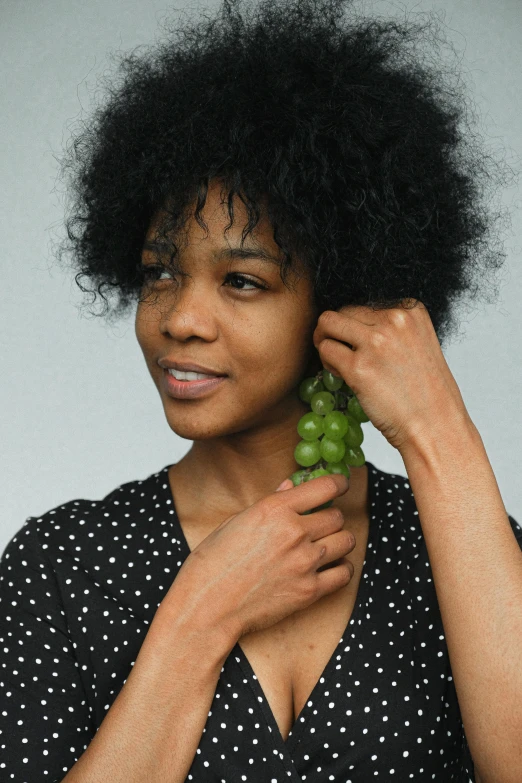 a woman with afro hair holding green gs