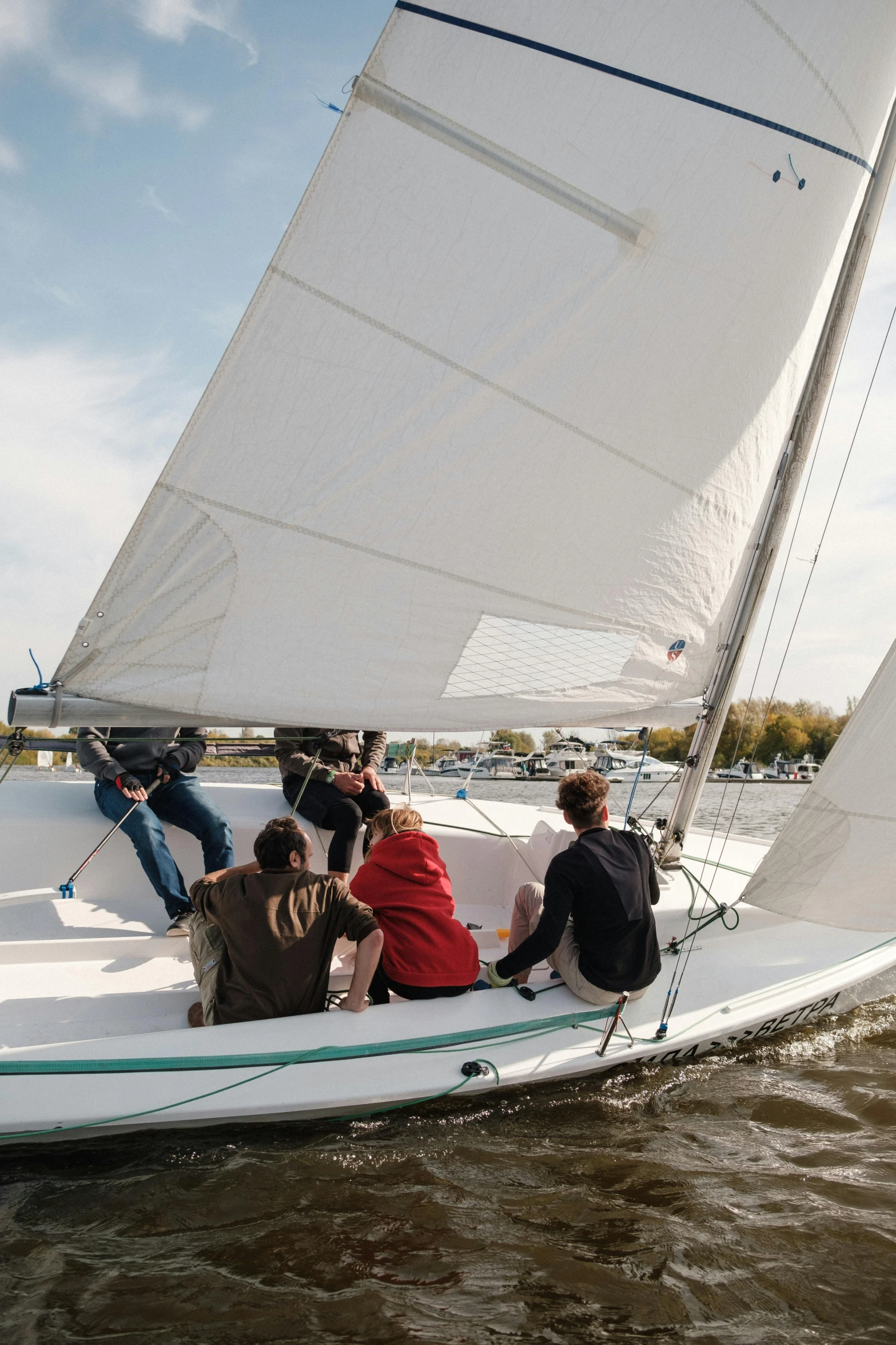 group of people sitting in a sailboat out on the water