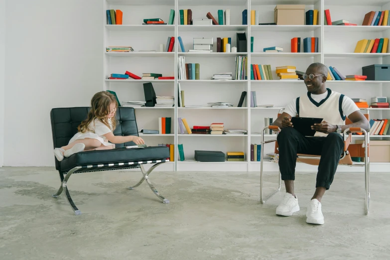 a man and a little girl sitting on a chair in a room