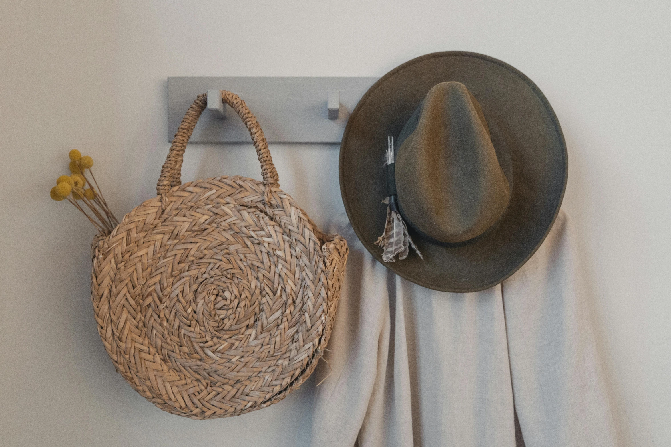 two hats and two baskets hanging on the wall