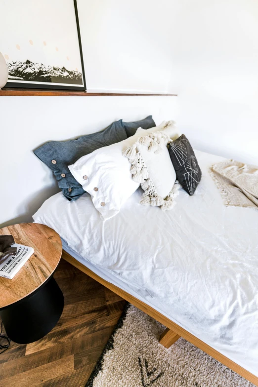 a bed sitting in the middle of a room with lots of pillows