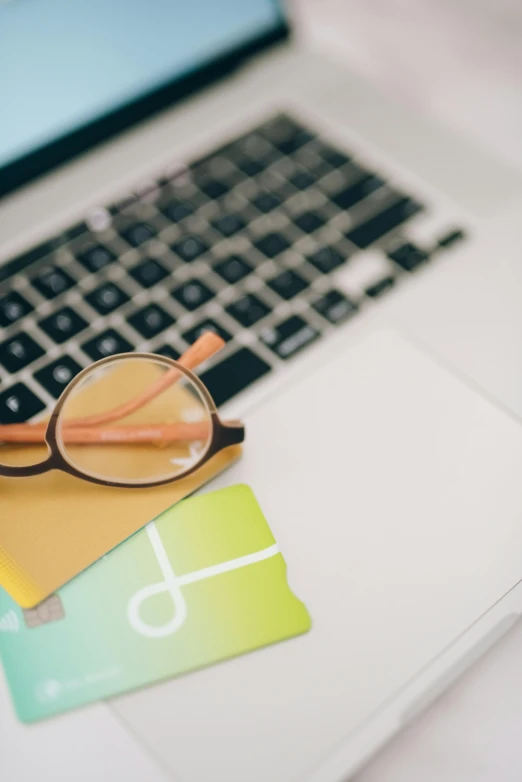 there is a close up picture of a keyboard and an eyeglass on top of a card