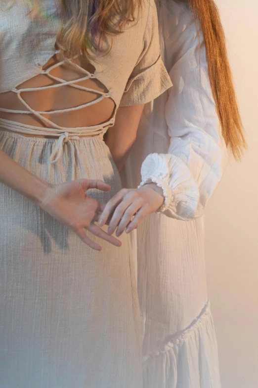 two woman with their hands together while posing