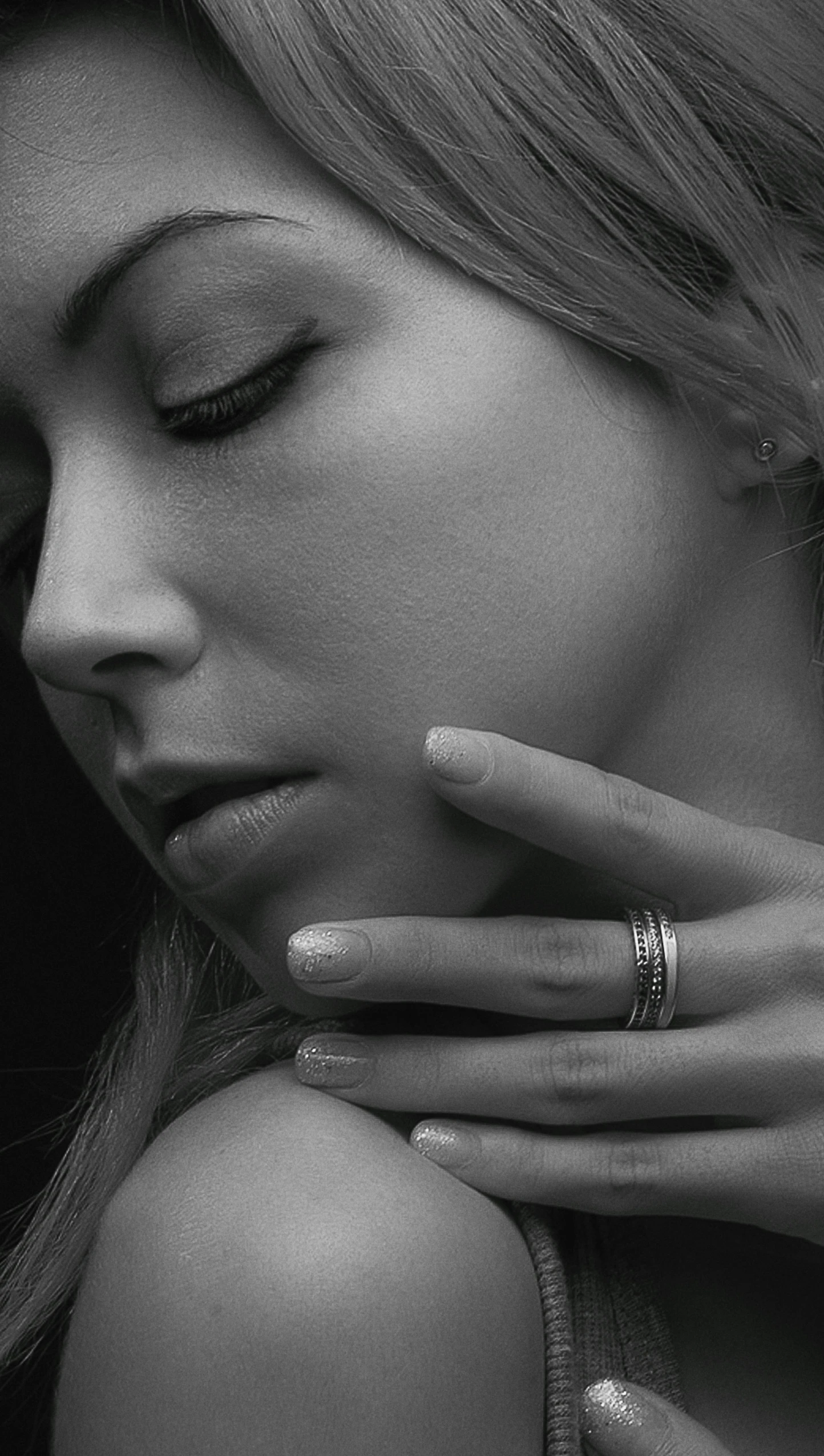 a black and white image of a woman's face with her fingers crossed next to her head