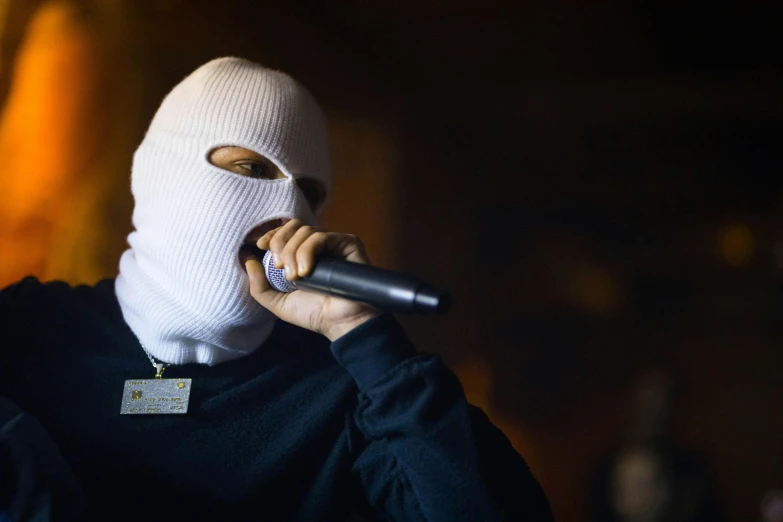 man with mask on talking on a microphone