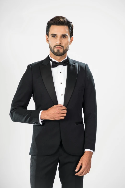 a man is wearing a suit with a black bow tie