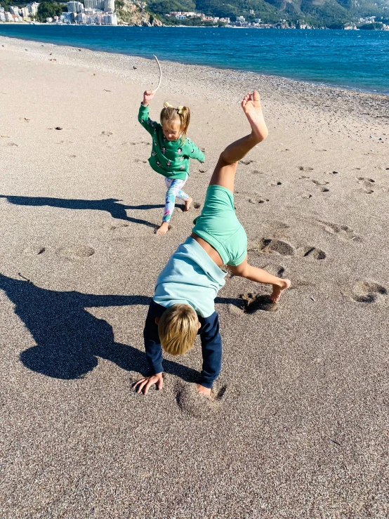 a little boy is playing in the sand by water