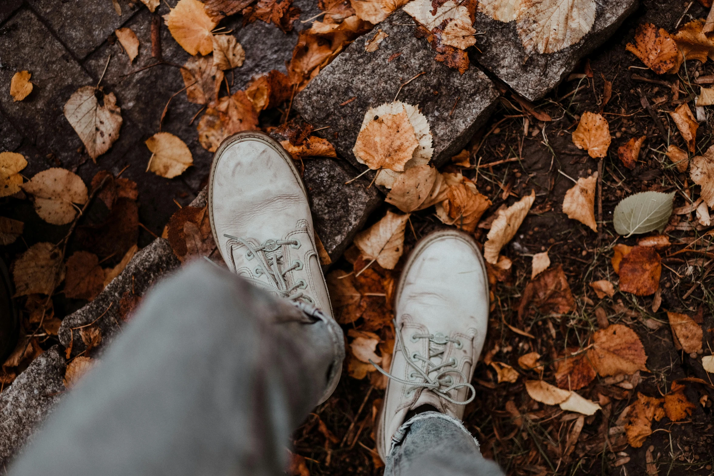 someone standing on the ground in dirty shoes