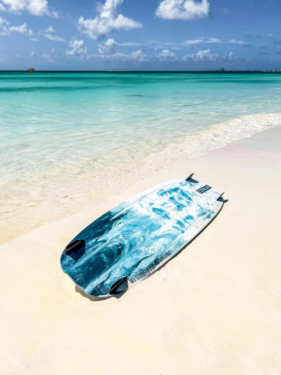 an open surfboard rests on the sand