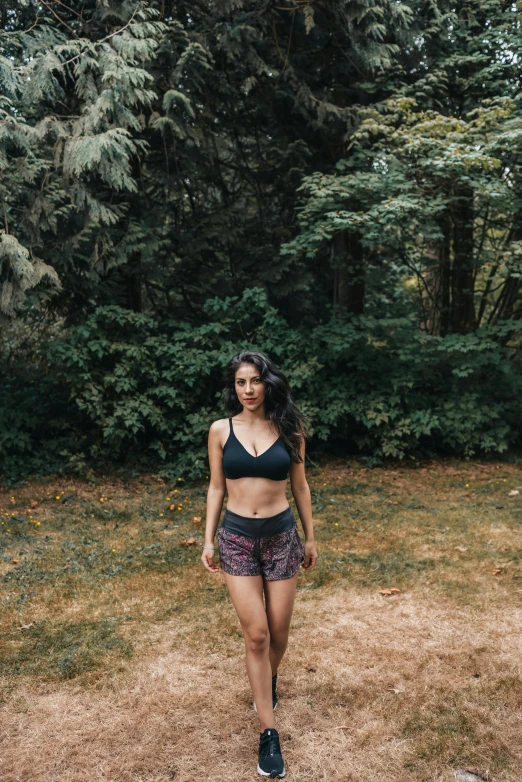 a woman walking with trees in the background