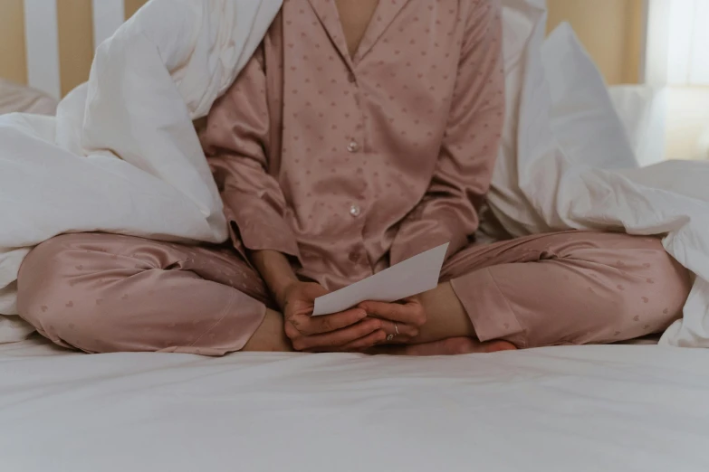 a person in pajamas sitting on a bed