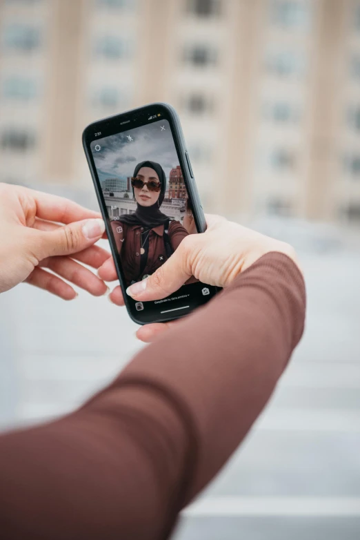 woman holding phone with po of woman looking at the screen