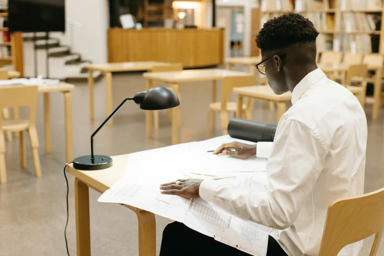 a man that is sitting at a table with paper