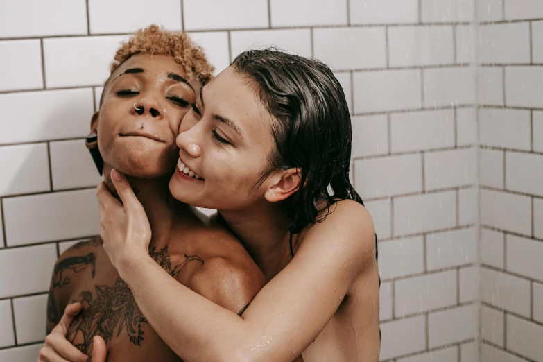 a couple of people standing in a bathroom sharing a kiss