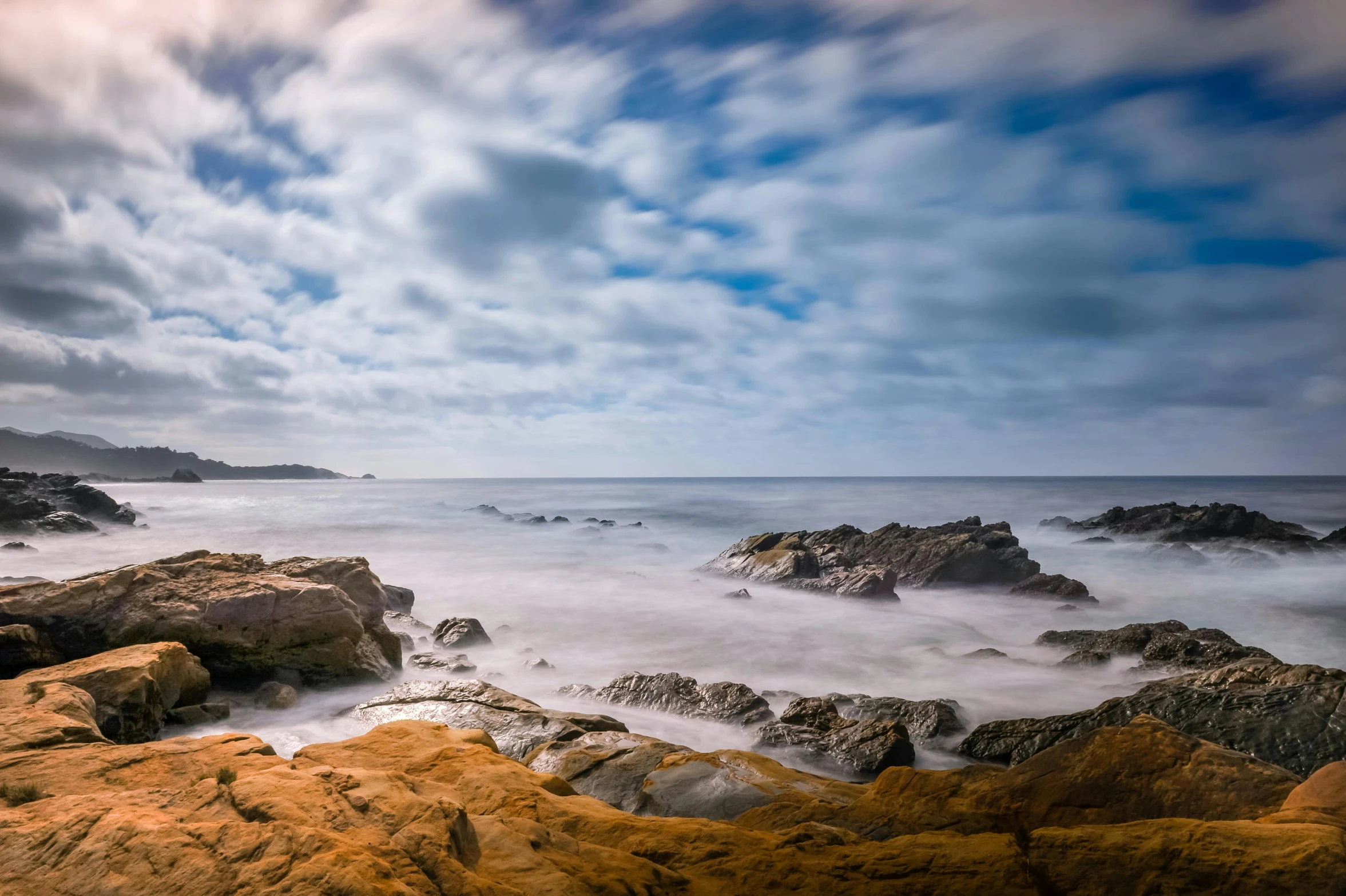 waves crash about rocks and reach toward the shore