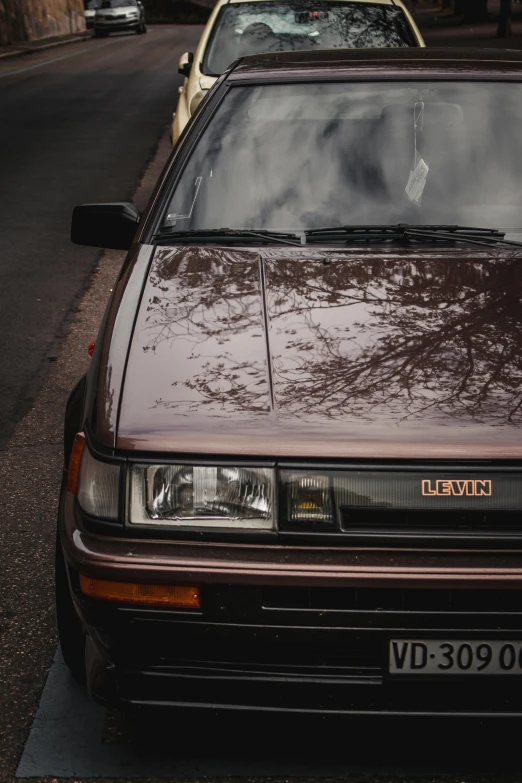 cars sit parked in front of each other on the street