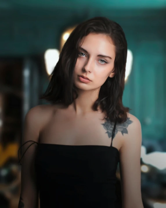 a young woman with black hair and piercings looking away from the camera