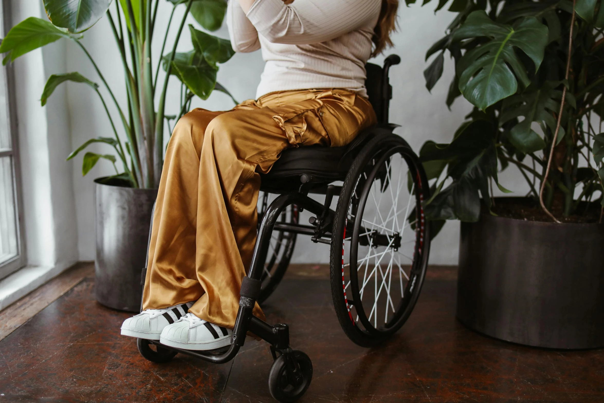 a woman sitting on a wheelchair, holding her phone up