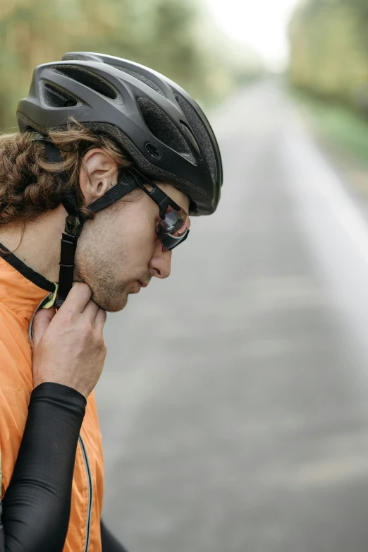 the man is adjusting his helmet on his bike