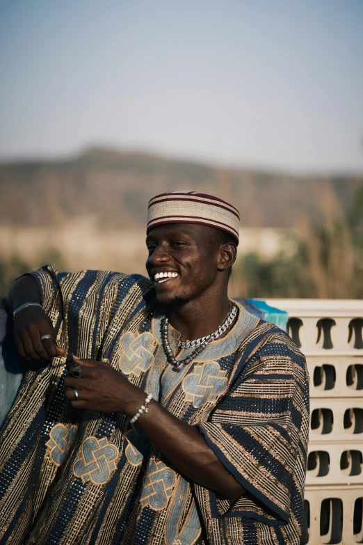 man dressed in ethnic clothing standing in a field