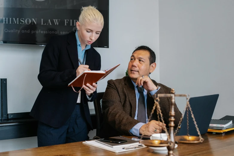 two women stand in front of a wooden table