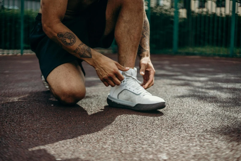 a man bent over tying his tennis shoes