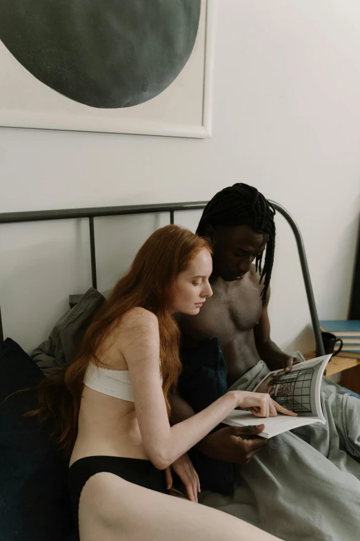 two beautiful women sitting on the bed, one with long hair