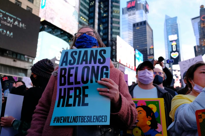 some people standing outside during the day, holding signs