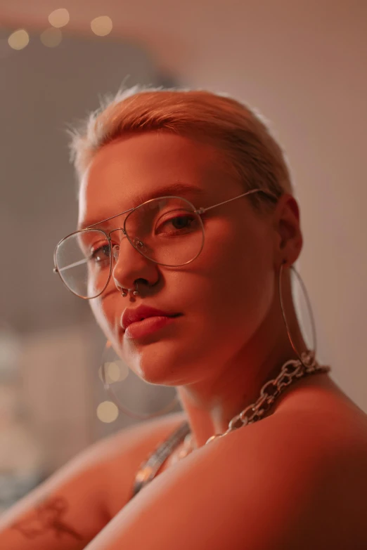 a woman wearing large hoop glasses looking off into the distance