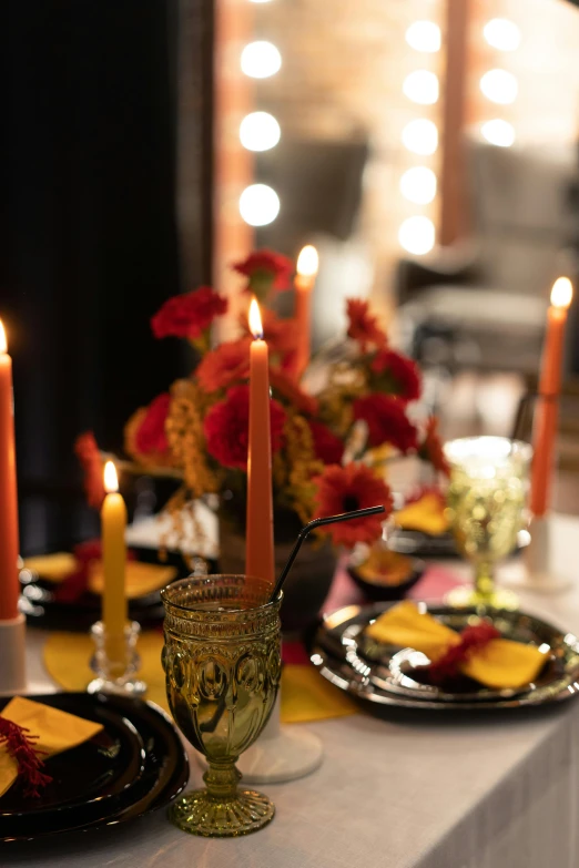 three lit candles set on a dinner table with yellow plates