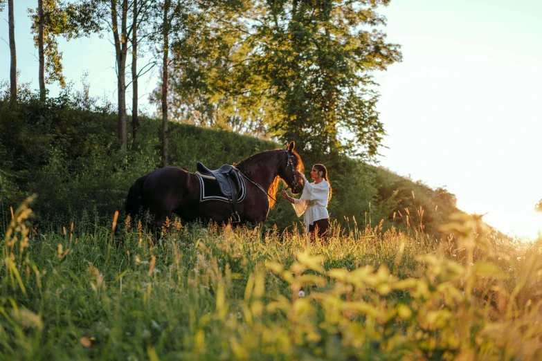 a woman and a child are standing next to a horse