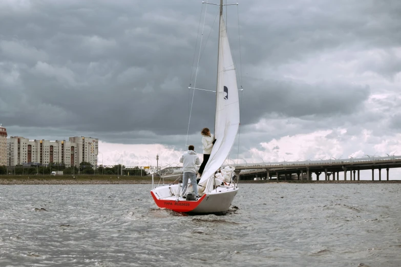 a couple of people riding on the back of a sail boat