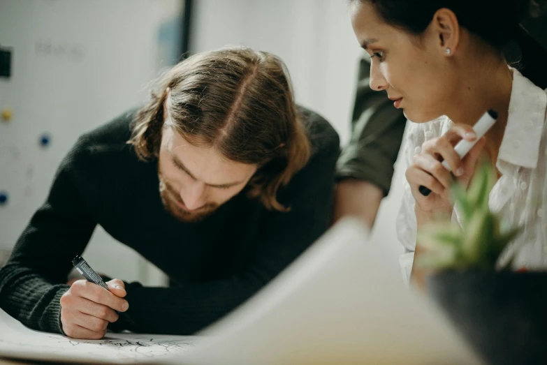 a woman signing on paper while her friend reads