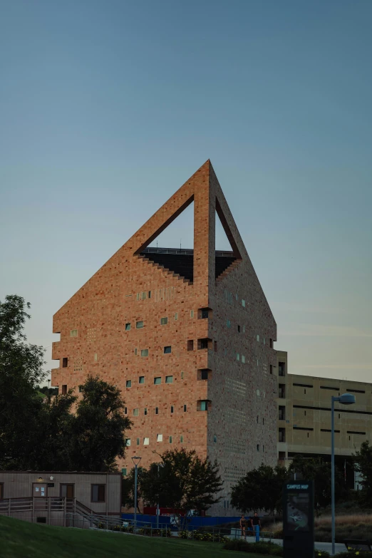 a building with triangular windows is shown on a hill