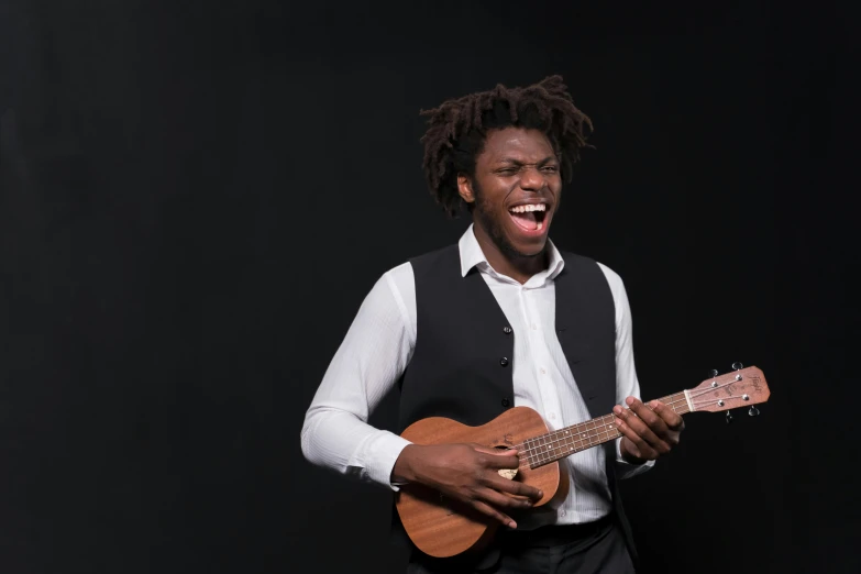 man with dreadlocks holding an ukulele