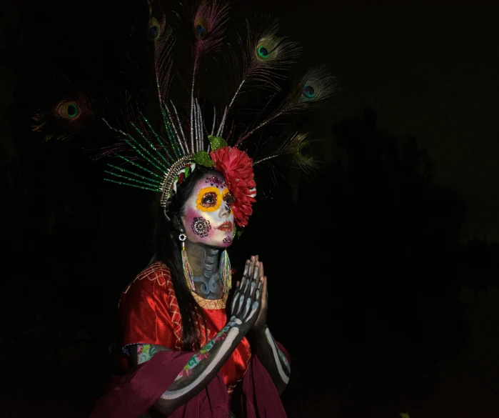 a woman with painted face and hand and body art wearing headdress