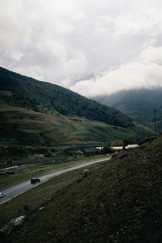 there is a sign on the side of the hill that has a lot of hills and mountains in the background