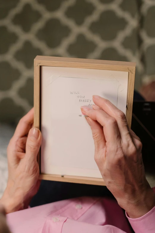 the older lady is holding her framed book