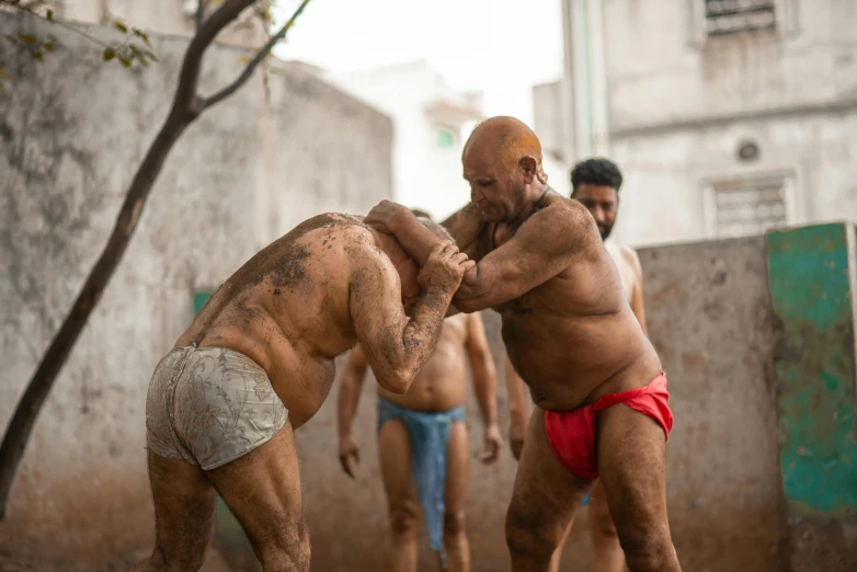 three men wearing underwear are on the street