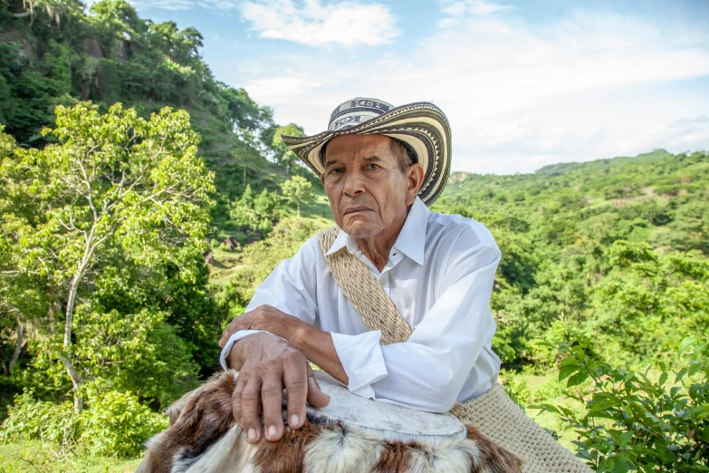 a man with a straw hat and tie sitting on a horse