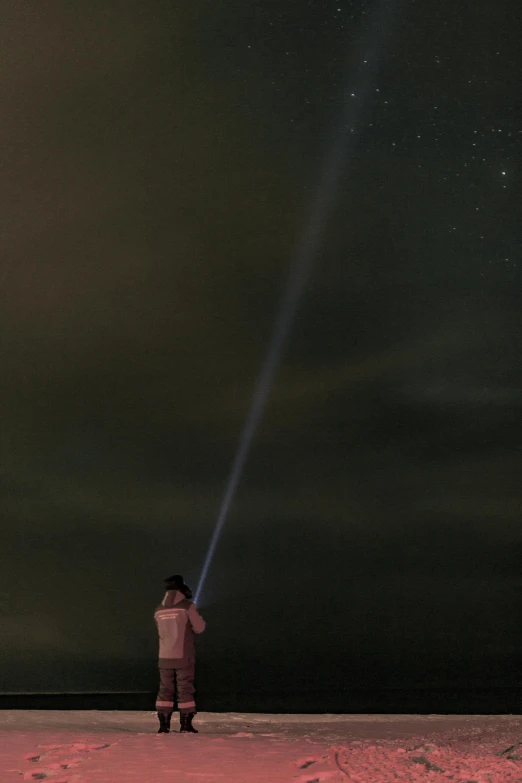 a person standing in the sand holding onto a laser