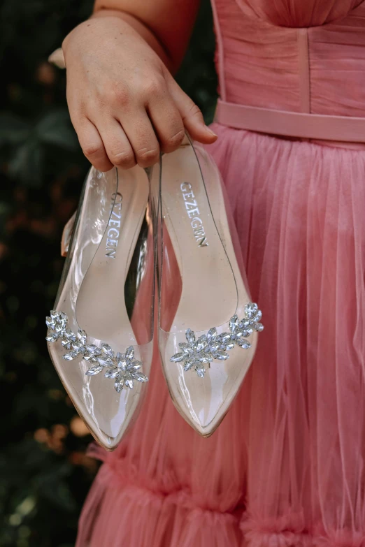 the woman is holding her wedding shoes in one hand and the other another