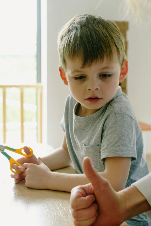 a  is holding a pair of yellow scissors