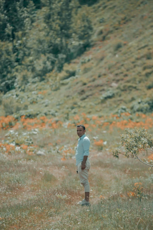 a man standing on top of a grass covered field