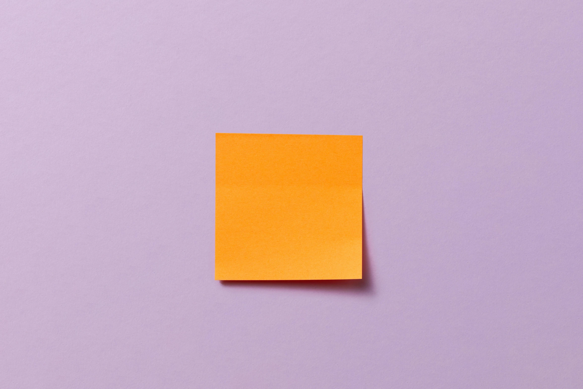 a yellow piece of paper is lying flat on a purple surface